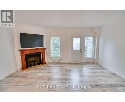 A room with a fireplace and a flat screen TV mounted on the wall.