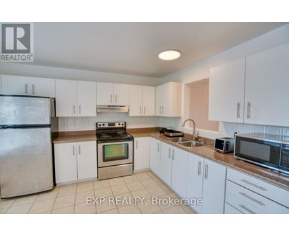 A kitchen with white cabinets and appliances is for sale.