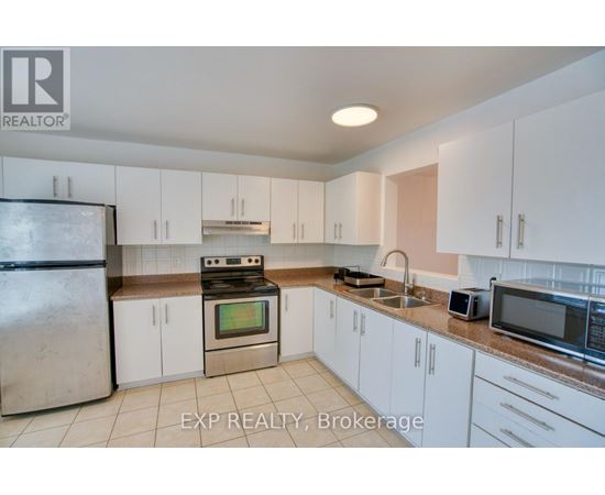 A kitchen with white cabinets and appliances is for sale.