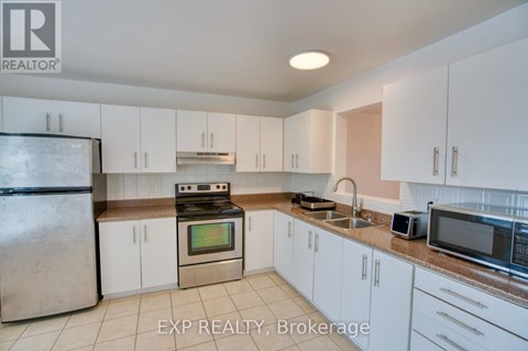 A kitchen with white cabinets and appliances is for sale.