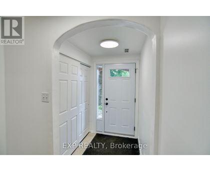 A white door is in a hallway with a light on the ceiling.