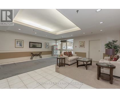 A well-lit living room with a couch, coffee table, and pictures on the wall.