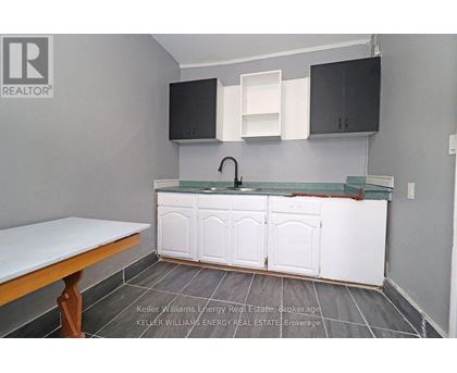 A kitchen with a white counter top and cabinets.