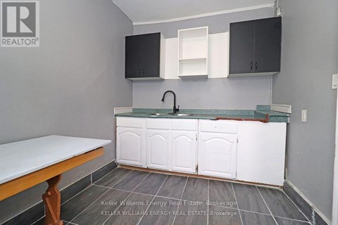 A kitchen with a white counter top and cabinets.
