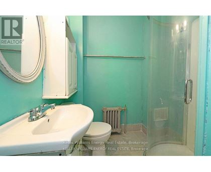 A bathroom with a sink, toilet and glass shower stall.