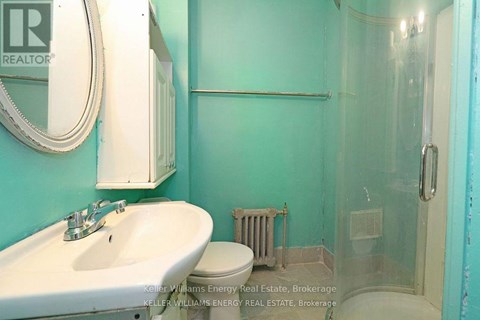 A bathroom with a sink, toilet and glass shower stall.