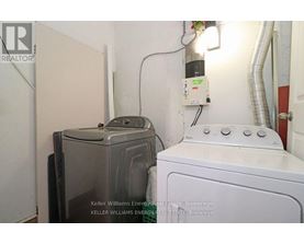 A white washing machine sits next to a dryer in a small room.