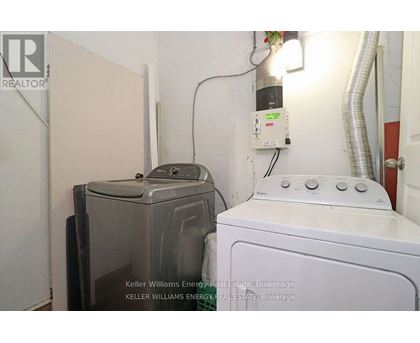 A white washing machine sits next to a dryer in a small room.