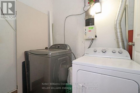 A white washing machine sits next to a dryer in a small room.