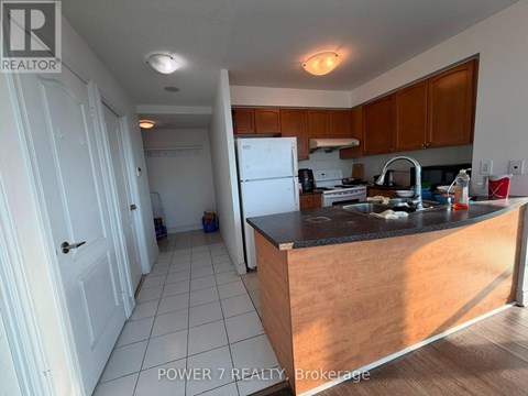 A kitchen with wooden cabinets and a black countertop.