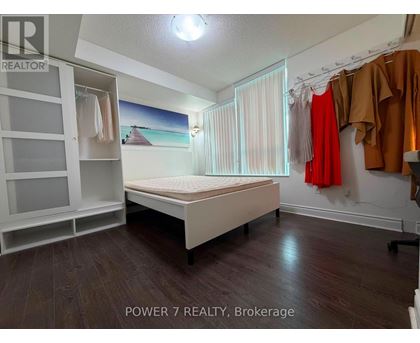 A bedroom with a bed, wardrobe, and a painting on the wall.