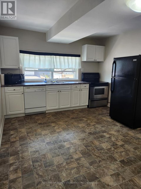 A kitchen with black appliances and white cabinets.
