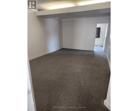 A room with carpeted floor and white walls.