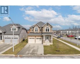 A house with a grey roof and a white garage door is for sale.