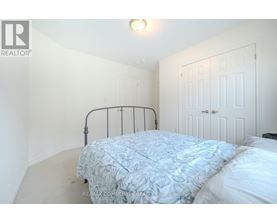 A bedroom with a bed and a white door.