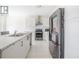 A modern kitchen with white cabinets and a stainless steel refrigerator.