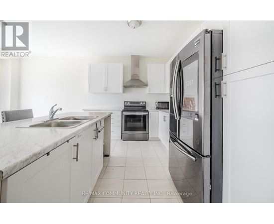 A modern kitchen with white cabinets and a stainless steel refrigerator.