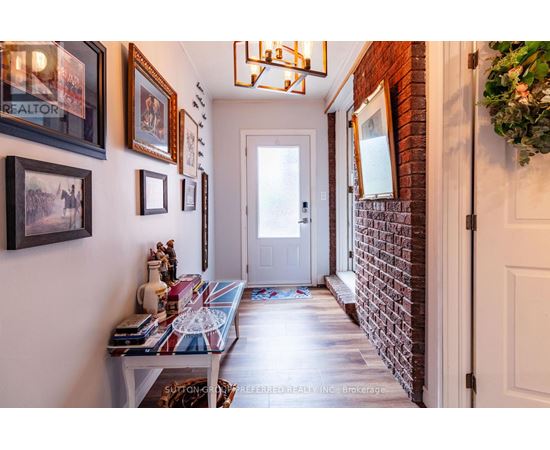 A hallway with a brick wall and a white door.