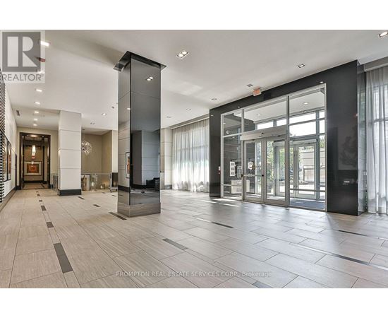 A hallway with a black and white color scheme and a glass door.