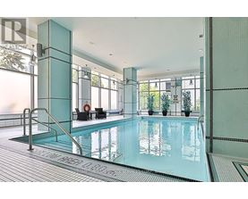 A large indoor swimming pool with a glass wall on one side.
