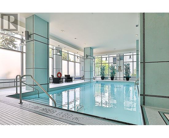 A large indoor swimming pool with a glass wall on one side.