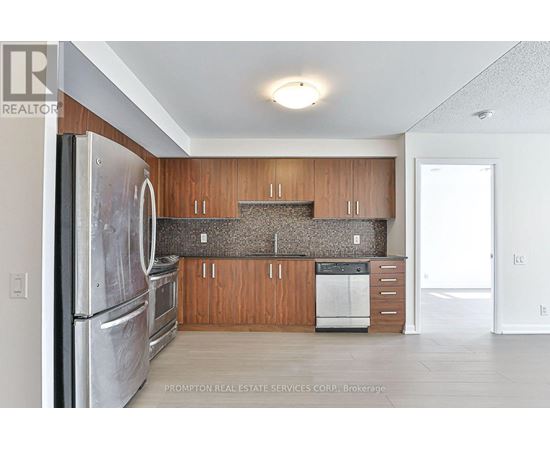 A kitchen with a refrigerator, oven, and cabinets.