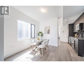 A well-lit, modern kitchen with a dining table set for four.