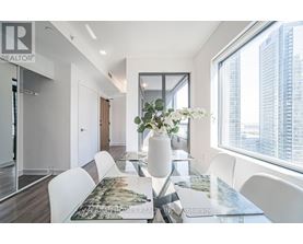 A modern dining room with a large table and chairs.
