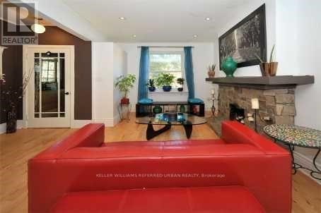 A living room with a red couch and a fireplace.