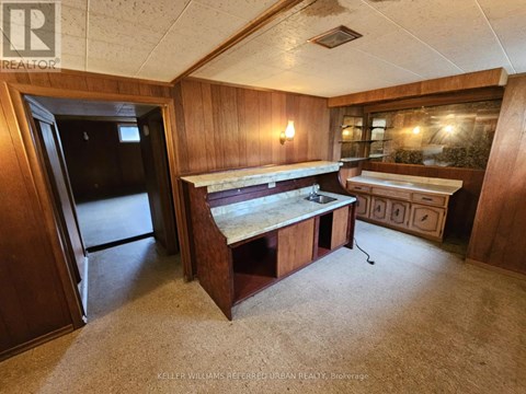 A kitchen area with a sink and a refrigerator.