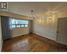A room with wooden floors and a window with curtains.