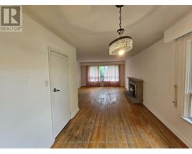 A room with a wooden floor and a chandelier hanging from the ceiling.