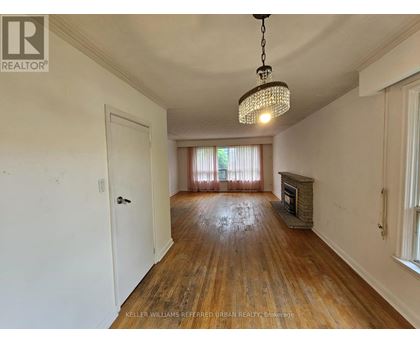 A room with a wooden floor and a chandelier hanging from the ceiling.