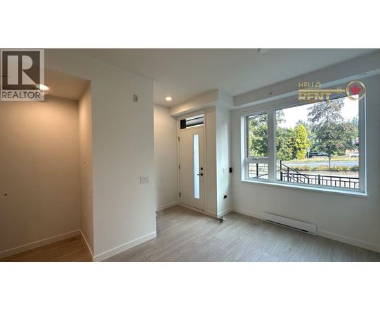 A room with a door and a window with a view of trees and a fence outside.