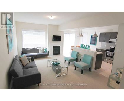 A living room with a couch, chairs, and a television.