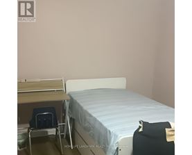 A bedroom with a bed, desk, and chair.