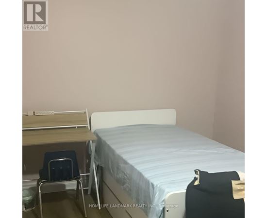 A bedroom with a bed, desk, and chair.