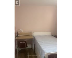 A bedroom with a bed, desk, and chair.