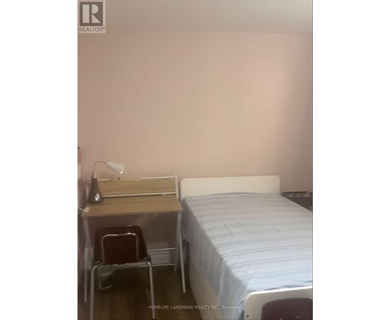 A bedroom with a bed, desk, and chair.