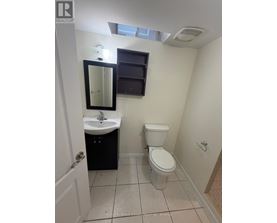 A small bathroom with a toilet, sink, and mirror.