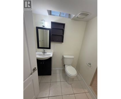 A small bathroom with a toilet, sink, and mirror.