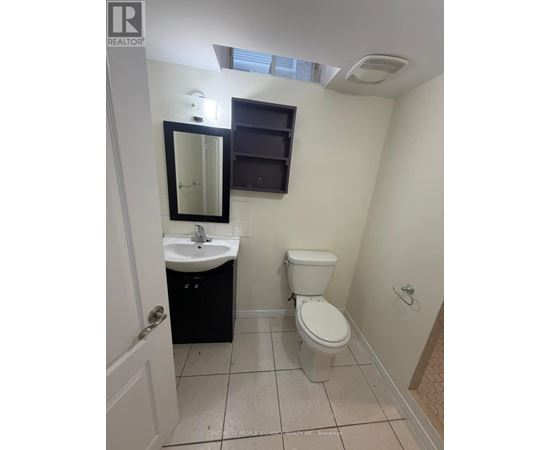 A small bathroom with a toilet, sink, and mirror.