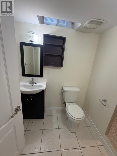 A small bathroom with a toilet, sink, and mirror.