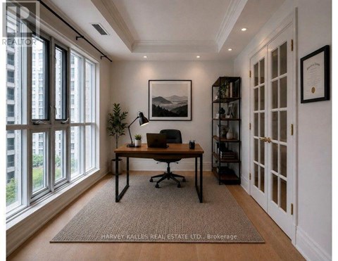 A room with a desk, chair, and a framed picture on the wall.