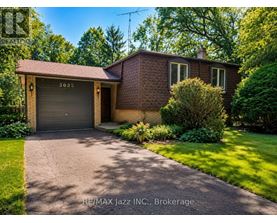 A house with a garage door numbered 3025 is for sale.