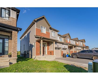 A row of townhouses with a car parked in front of the first one.