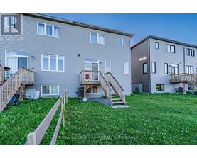A grassy area in front of two apartment buildings with wooden railings.