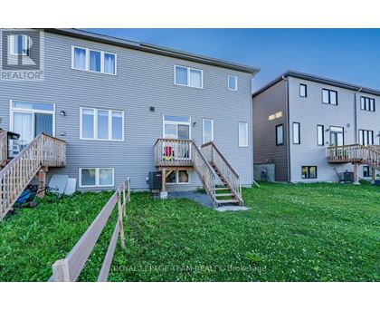 A grassy area in front of two apartment buildings with wooden railings.