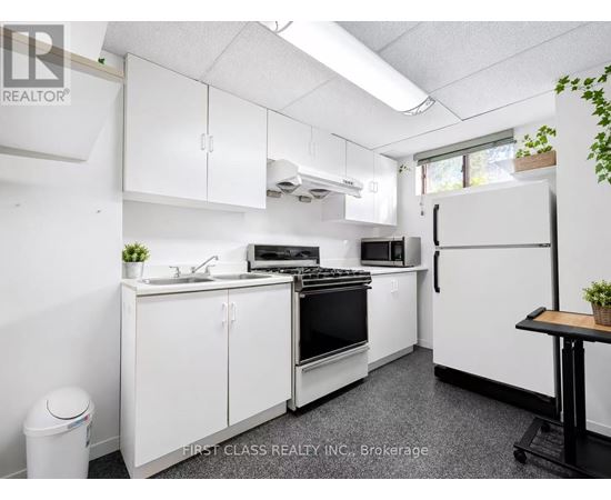 A small, white kitchen with a black stove top oven.