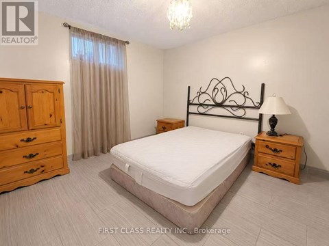 A bedroom with a bed, dresser, and nightstand.